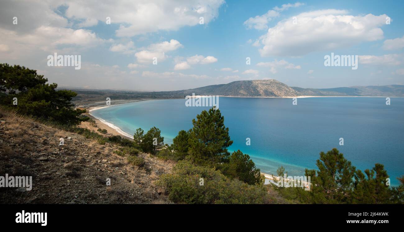 Ruhige Aussicht auf einen schönen See. Wolken und Hügel spiegeln sich im türkisfarbenen Seenwasser. Stockfoto