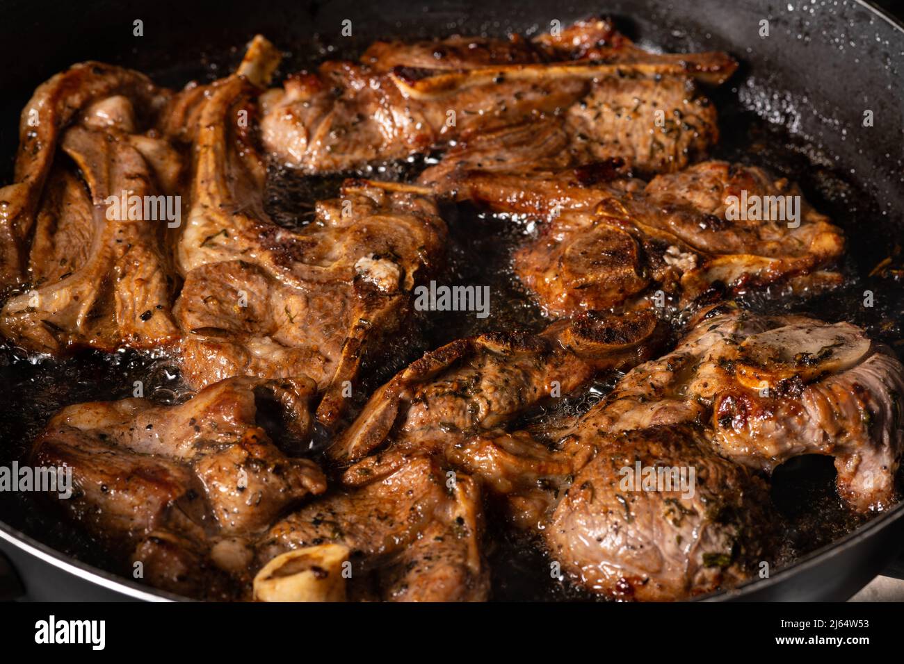 Kochen von Lammkoteletts in einer Pfanne. Kochen auf einem Gasherd. Stockfoto