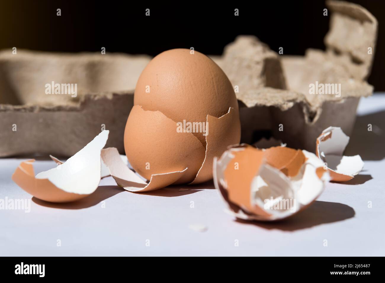 Eistahorn mit gebrochenem Ei, mit schwarzem Hintergrund, nahrhaftes Essen, Protein, Lebensmittelkonzept Stockfoto
