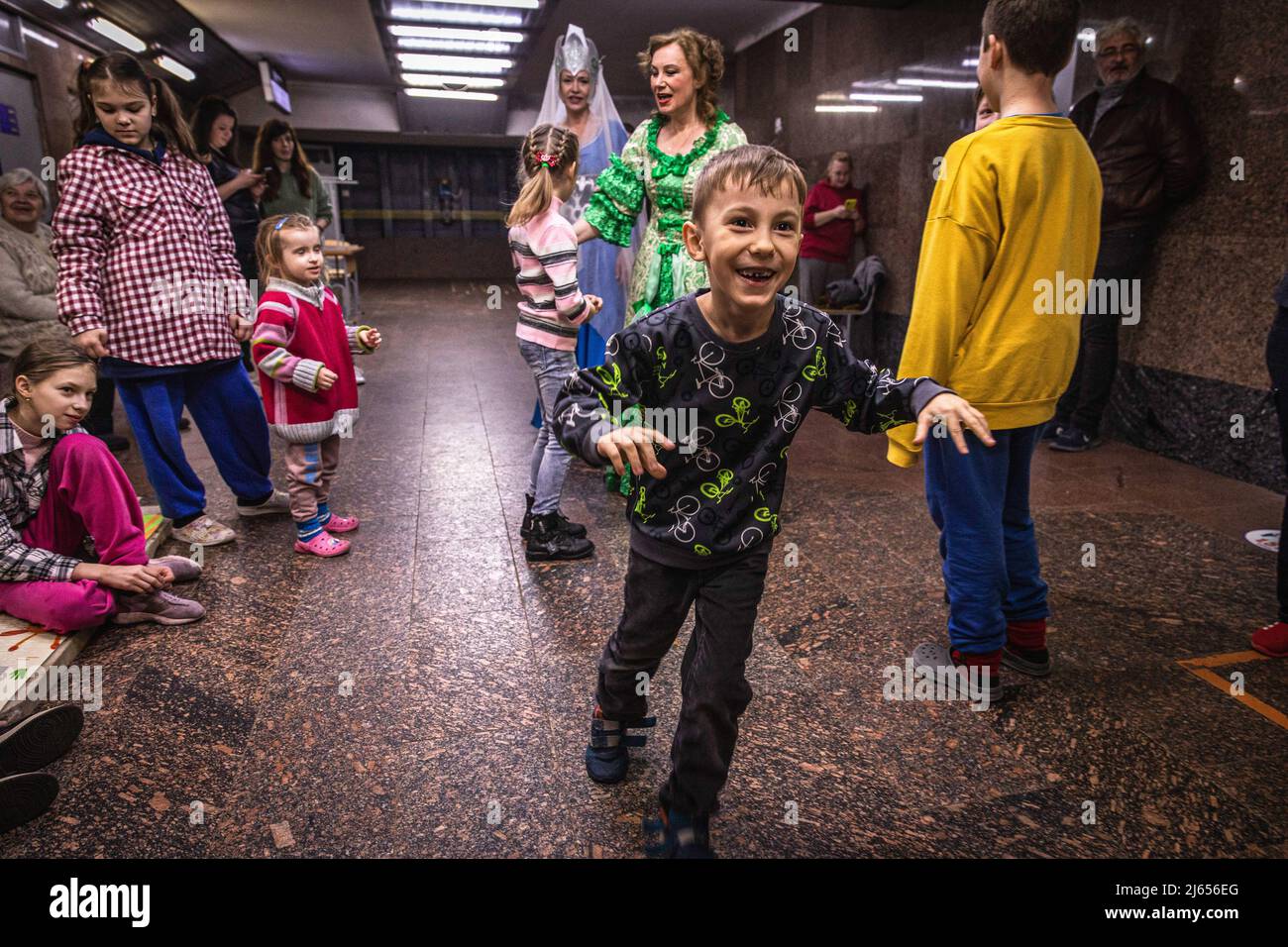 Ein Junge, der während der Theateraufführung in einer U-Bahn-Station in Charkiw, Ukraine, spielt. Die Schauspielerin Olga Druschenko sagte, dass alle ihre Kollegen in andere Länder evakuiert hätten, sie sei wegen ihres alten Vaters geblieben, der jetzt 80 Jahre alt ist. Da sie auch in der U-Bahn lebt, fühlt sie sich unter der Erde viel sicherer. Die Bürger in Charkiw wurden gezwungen, ein neues Leben in der U-Bahn-Stationen zu übernehmen, da die zweitgrößte Stadt in der Ukraine jetzt unter ständiger Bedrohung durch russische Bombardierung und konfrontiert Stockfoto