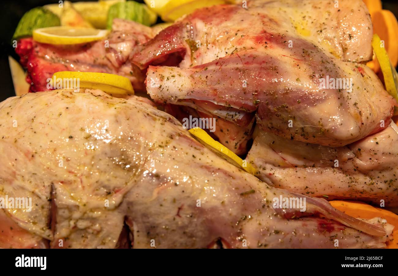 Lammkeule mit Knochen, ungekocht mit Kartoffeln und Kräutern in der Backform. Zubereitung von traditionellen griechischen Osterspeisen, mariniertem Ziegen- oder Schaffleisch mit frischem Ve Stockfoto