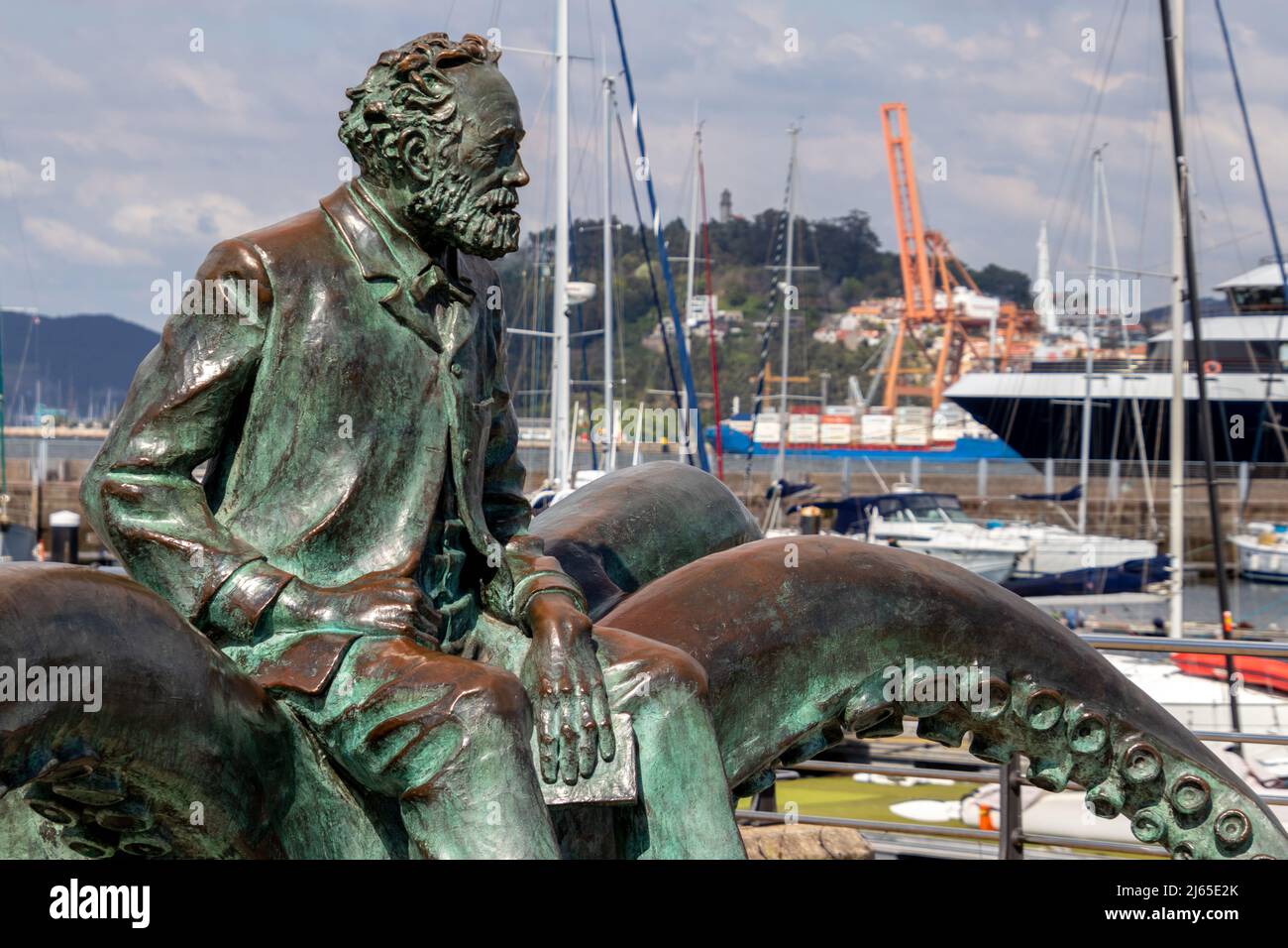 Vigo, Spanien - 25. Apr 2020: Statue des französischen Schriftstellers Jules Verne mit einem Buch, das auf einem Oktopus im Hafen von Vigo sitzt Stockfoto