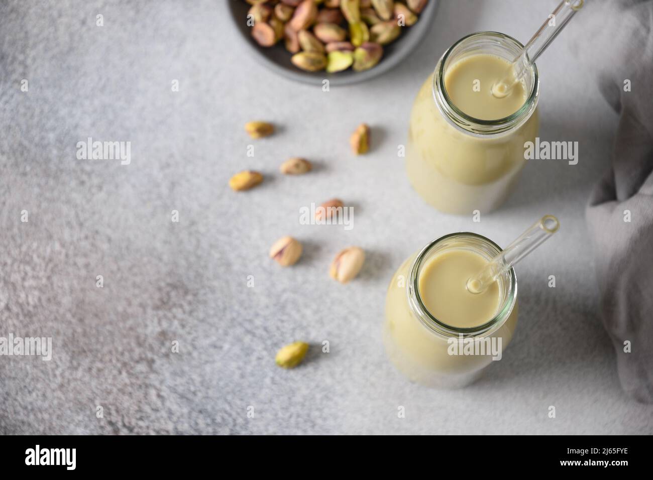 Gesunde Pistazien-Milch auf grauem Hintergrund. Horizontale Ausrichtung ...
