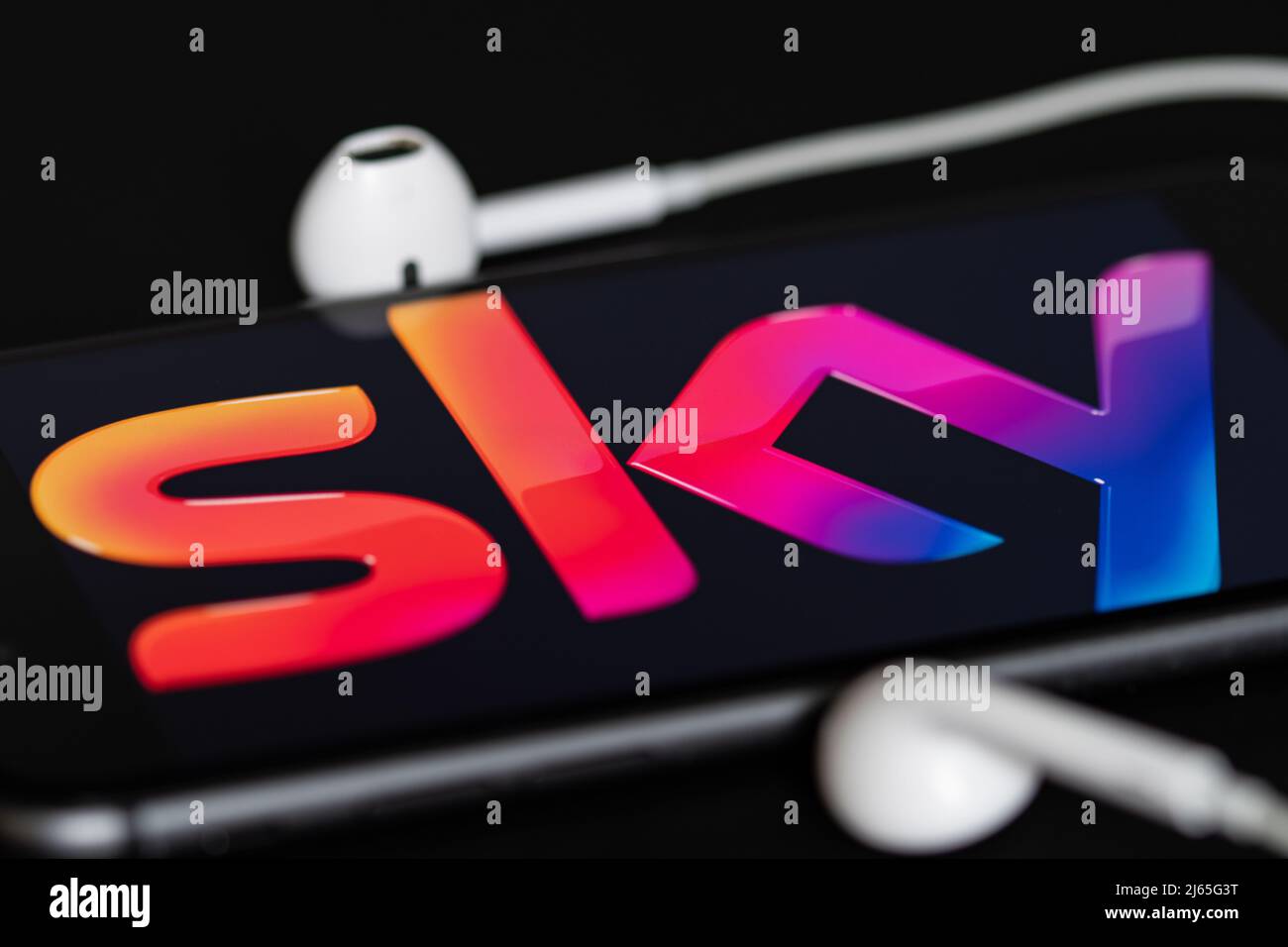 Rheinbach, Deutschland 28. April 2022, das Markenlogo des Pay-TV-Anbieters 'Sky' auf dem Display eines Smartphones mit Kopfhörern Stockfoto