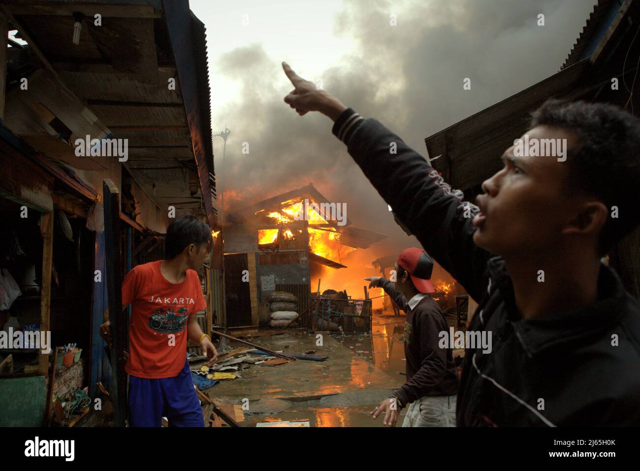 Bewohner koordinieren sich, während sie versuchen, bei der Brandbekämpfung zu helfen, da ein Feuerunfall in einem dichten Viertel in Penjaringan, Nord-Jakarta, Jakarta, Indonesien, brennt. Im Zeitraum von zehn Jahren (2011-2020) kamen 269 Menschen durch Brandunfälle ums Leben – durchschnittlich 26,9 pro Jahr. Es gab 164 Fälle von Feuerwehrleuten, die bei Löscharbeiten verletzt wurden. Ein Feuerwehrmann verlor im gleichen Zeitraum das Leben. Stockfoto
