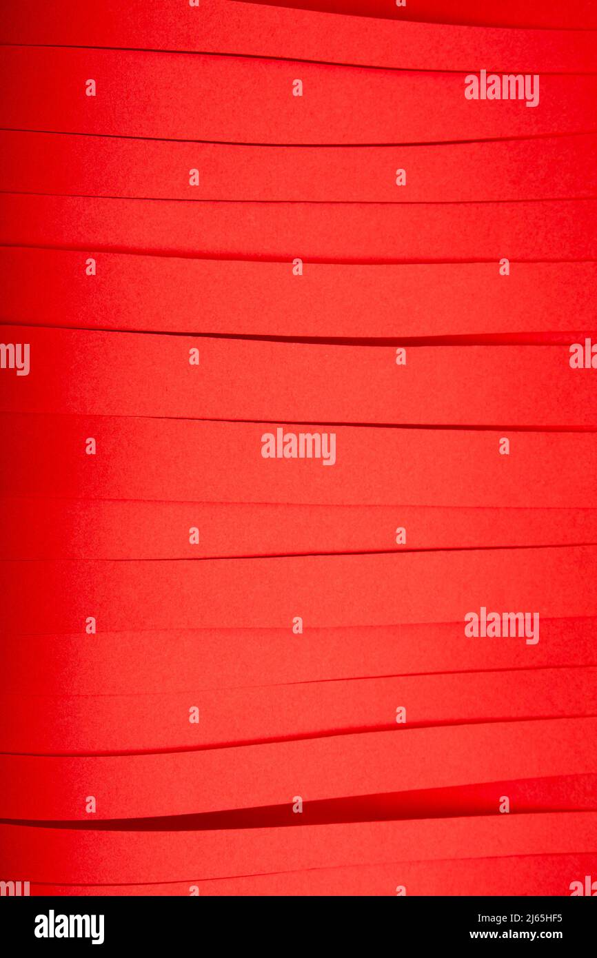 Abstrakte rote Papierstreifen Hintergrund mit parallelen Linien. Blutrote Papierstücke Textur. Stockfoto