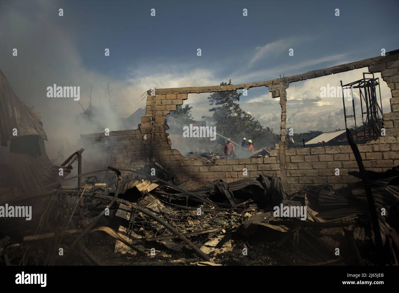 Mitglieder der Löschgruppe von Jakarta, die die Abkühlphase nach einem Feuerunfall durchführten, verbrannten Lagergebäude einer Heimindustrie in Kebayoran Lama, Süd-Jakarta, Jakarta, Indonesien. Stockfoto