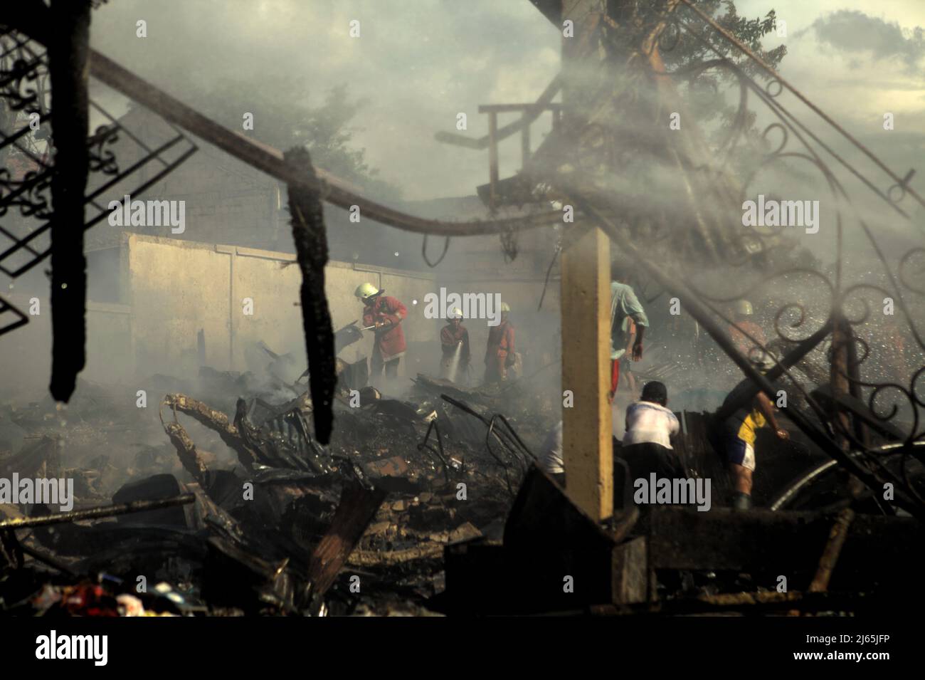 Mitglieder der Löschgruppe von Jakarta, die nach einem Feuerunfall zwischen Trümmern arbeitete, verbrannten Lagergebäude einer Heimindustrie in Kebayoran Lama, South Jakarta, Jakarta, Indonesien. Stockfoto