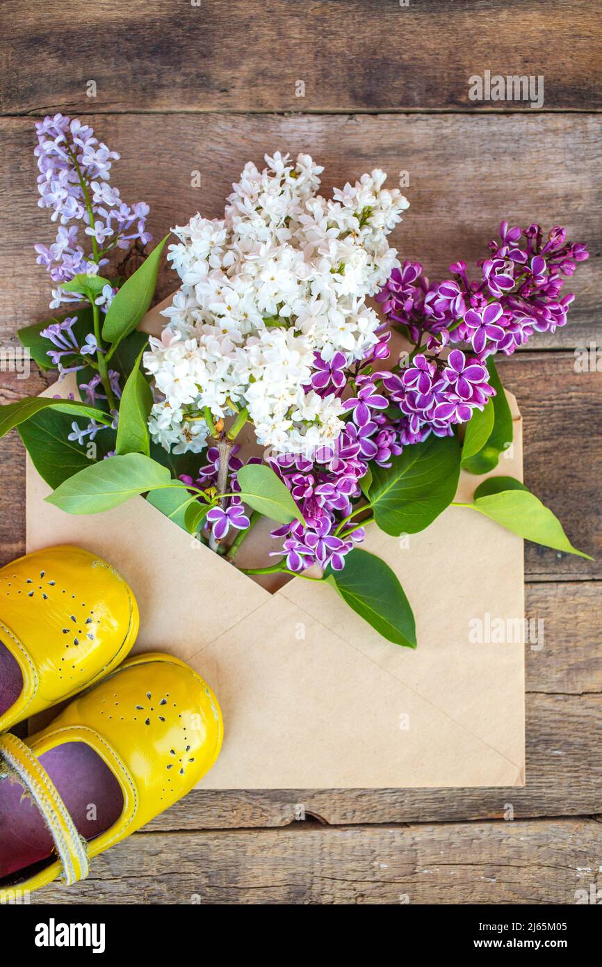 Fliederblumen Frühlingsblüten, Retro-Kinderschuhe und alte Kamera Stockfoto
