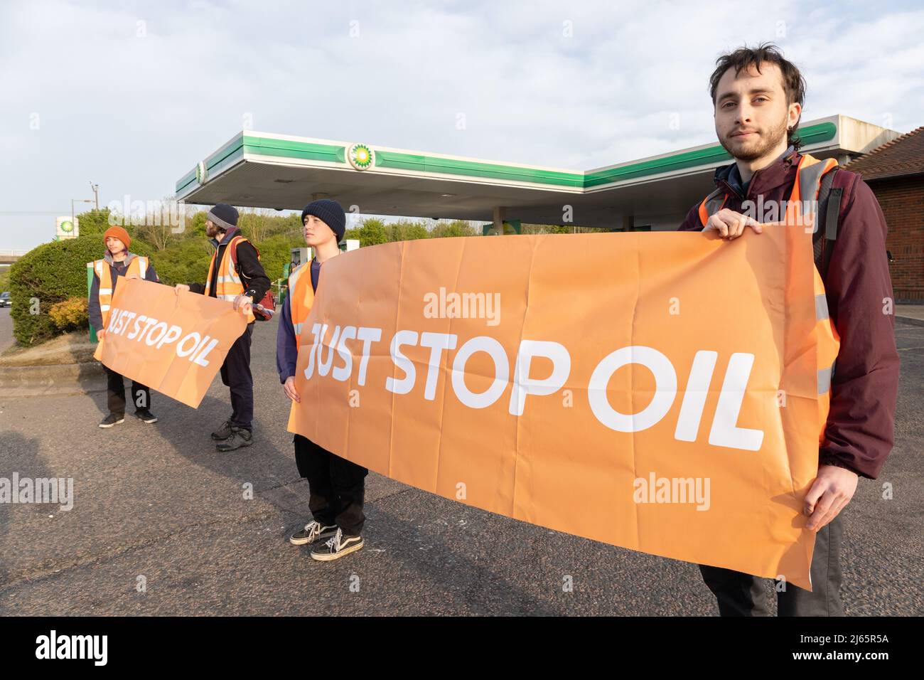 Kent, Großbritannien. 28. April 2022 Demonstranten von Just Stop Oil blockieren die BP-Garage bei Clacket Lane Services am M25. Sie fordern die Regierung auf, die Gewinnung neuer fossiler Brennstoffe sowie die Gas- und Ölbohrungen zu beenden und sie zu drängen, stattdessen in erneuerbare Energien zu investieren. Demonstranten zerschlagen das Glas auf Benzinpumpen und Graffiti über der Front und kleben sich schließlich an die Pumpen Credit: Denise Laura Baker/Alamy Live News Credit: Denise Laura Baker/Alamy Live News Stockfoto