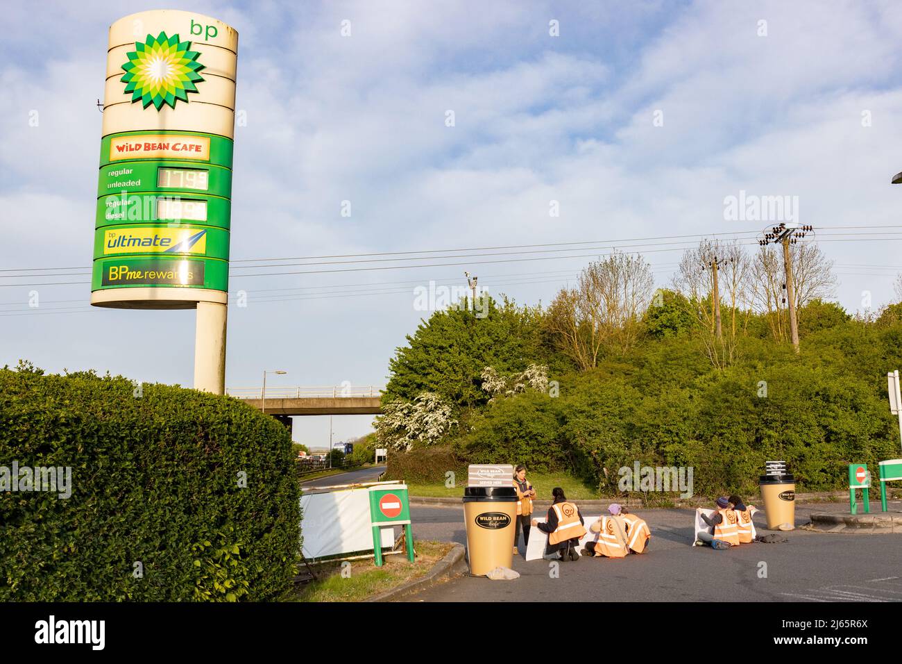 Kent, Großbritannien. 28. April 2022 Demonstranten von Just Stop Oil blockieren die BP-Garage bei Clacket Lane Services am M25. Sie fordern die Regierung auf, die Gewinnung neuer fossiler Brennstoffe sowie die Gas- und Ölbohrungen zu beenden und sie zu drängen, stattdessen in erneuerbare Energien zu investieren. Demonstranten zerschlagen das Glas auf Benzinpumpen und Graffiti über der Front und kleben sich schließlich an die Pumpen Credit: Denise Laura Baker/Alamy Live News Credit: Denise Laura Baker/Alamy Live News Stockfoto