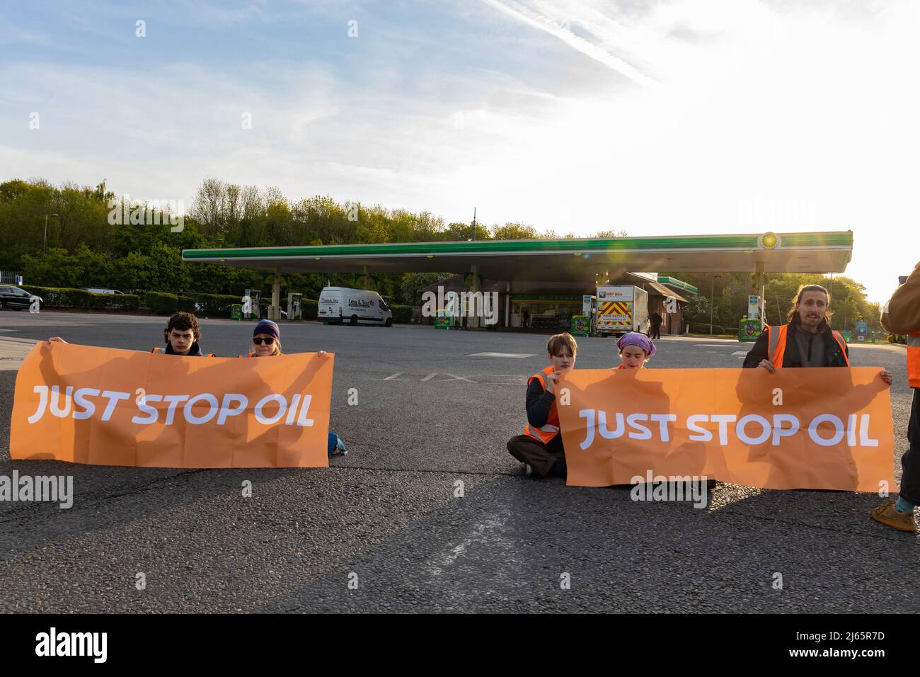 Kent, Großbritannien. 28. April 2022 Demonstranten von Just Stop Oil blockieren die BP-Garage bei Clacket Lane Services am M25. Sie fordern die Regierung auf, die Gewinnung neuer fossiler Brennstoffe sowie die Gas- und Ölbohrungen zu beenden und sie zu drängen, stattdessen in erneuerbare Energien zu investieren. Demonstranten zerschlagen das Glas auf Benzinpumpen und Graffiti über der Front und kleben sich schließlich an die Pumpen Credit: Denise Laura Baker/Alamy Live News Credit: Denise Laura Baker/Alamy Live News Stockfoto