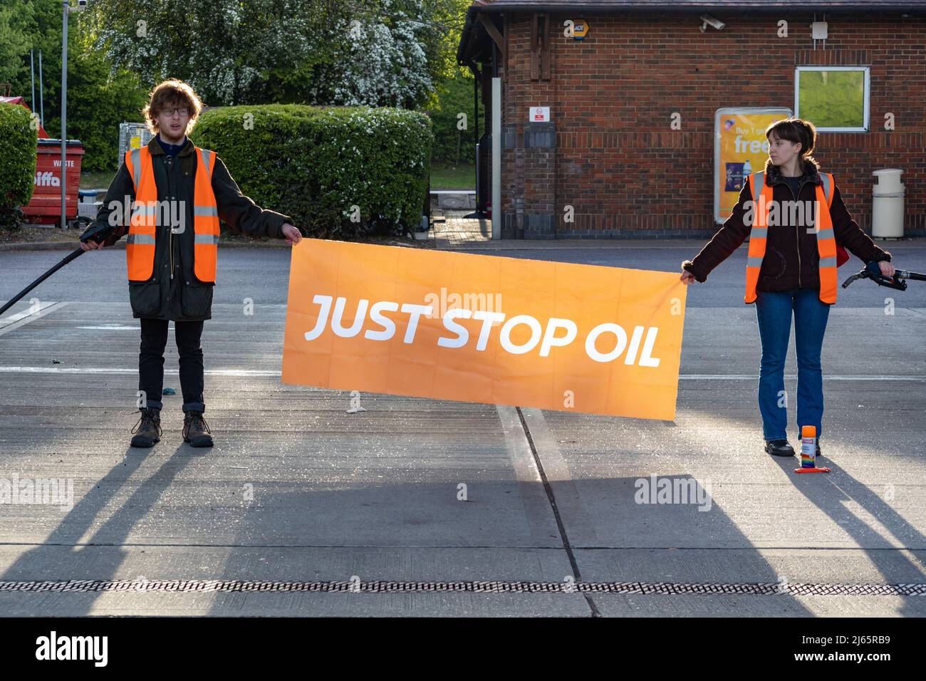 Kent, Großbritannien. 28. April 2022 Demonstranten von Just Stop Oil blockieren die BP-Garage bei Clacket Lane Services am M25. Sie fordern die Regierung auf, die Gewinnung neuer fossiler Brennstoffe sowie die Gas- und Ölbohrungen zu beenden und sie zu drängen, stattdessen in erneuerbare Energien zu investieren. Demonstranten zerschlagen das Glas auf Benzinpumpen und Graffiti über der Front und kleben sich schließlich an die Pumpen Credit: Denise Laura Baker/Alamy Live News Credit: Denise Laura Baker/Alamy Live News Stockfoto