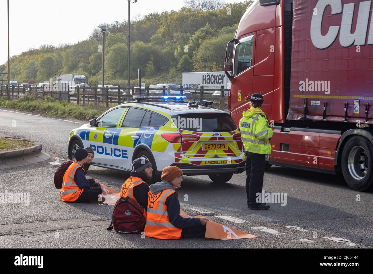 Kent, Großbritannien. 28. April 2022 Demonstranten von Just Stop Oil blockieren die BP-Garage bei Clacket Lane Services am M25. Sie fordern die Regierung auf, die Gewinnung neuer fossiler Brennstoffe sowie die Gas- und Ölbohrungen zu beenden und sie zu drängen, stattdessen in erneuerbare Energien zu investieren. Demonstranten zerschlagen das Glas auf Benzinpumpen und Graffiti über der Front und kleben sich schließlich an die Pumpen Credit: Denise Laura Baker/Alamy Live News Credit: Denise Laura Baker/Alamy Live News Stockfoto