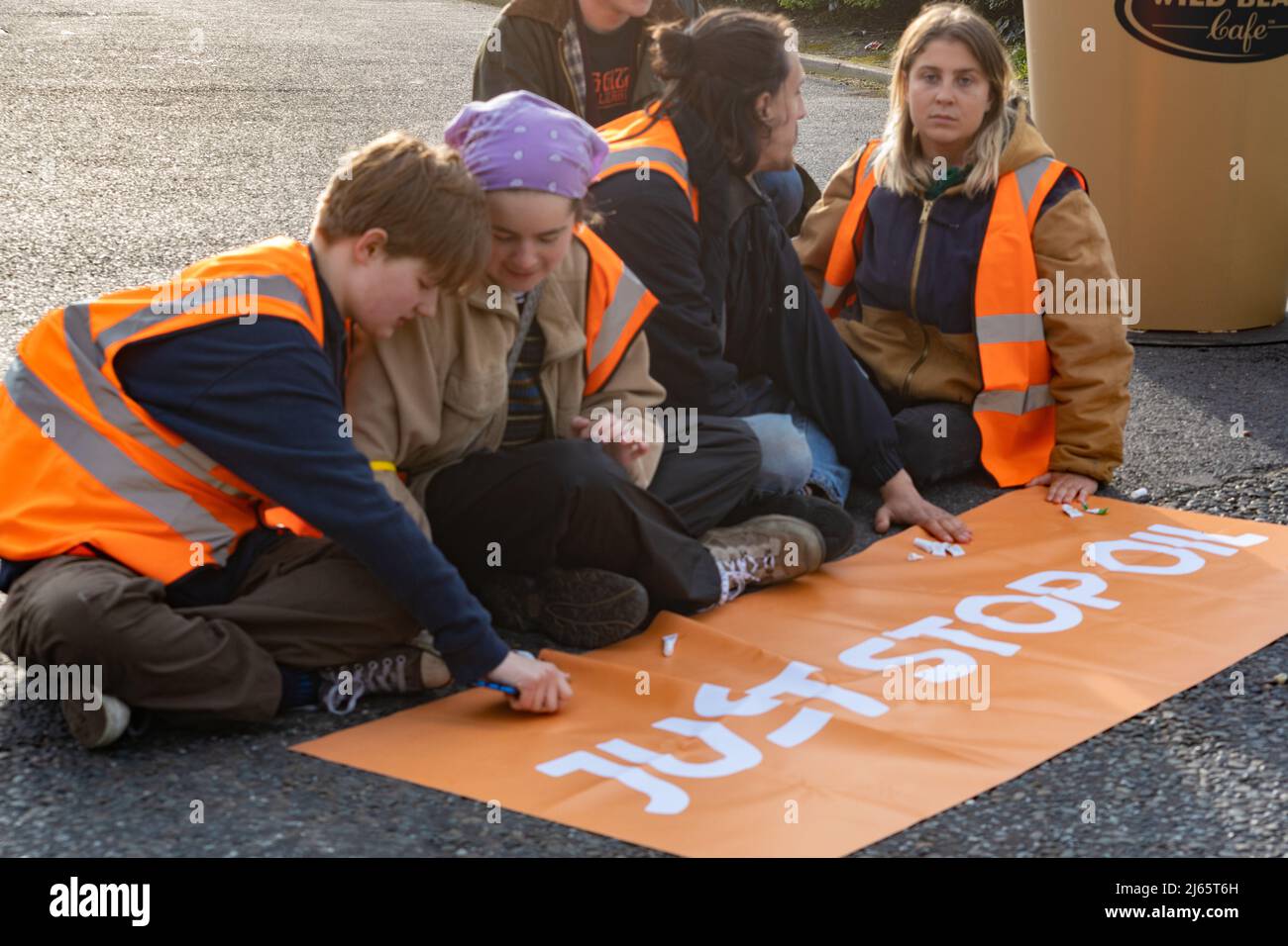 Kent, Großbritannien. 28. April 2022 Demonstranten von Just Stop Oil blockieren die BP-Garage bei Clacket Lane Services am M25. Sie fordern die Regierung auf, die Gewinnung neuer fossiler Brennstoffe sowie die Gas- und Ölbohrungen zu beenden und sie zu drängen, stattdessen in erneuerbare Energien zu investieren. Demonstranten zerschlagen das Glas auf Benzinpumpen und Graffiti über der Front und kleben sich schließlich an die Pumpen Credit: Denise Laura Baker/Alamy Live News Credit: Denise Laura Baker/Alamy Live News Stockfoto