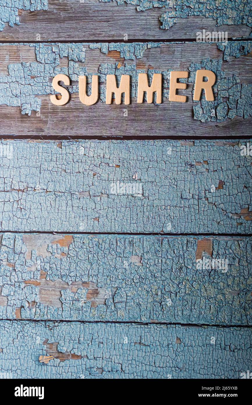 Sommerwort auf Holzbuchstaben geschrieben Text auf einer strukturierten blauen Oberfläche Stockfoto