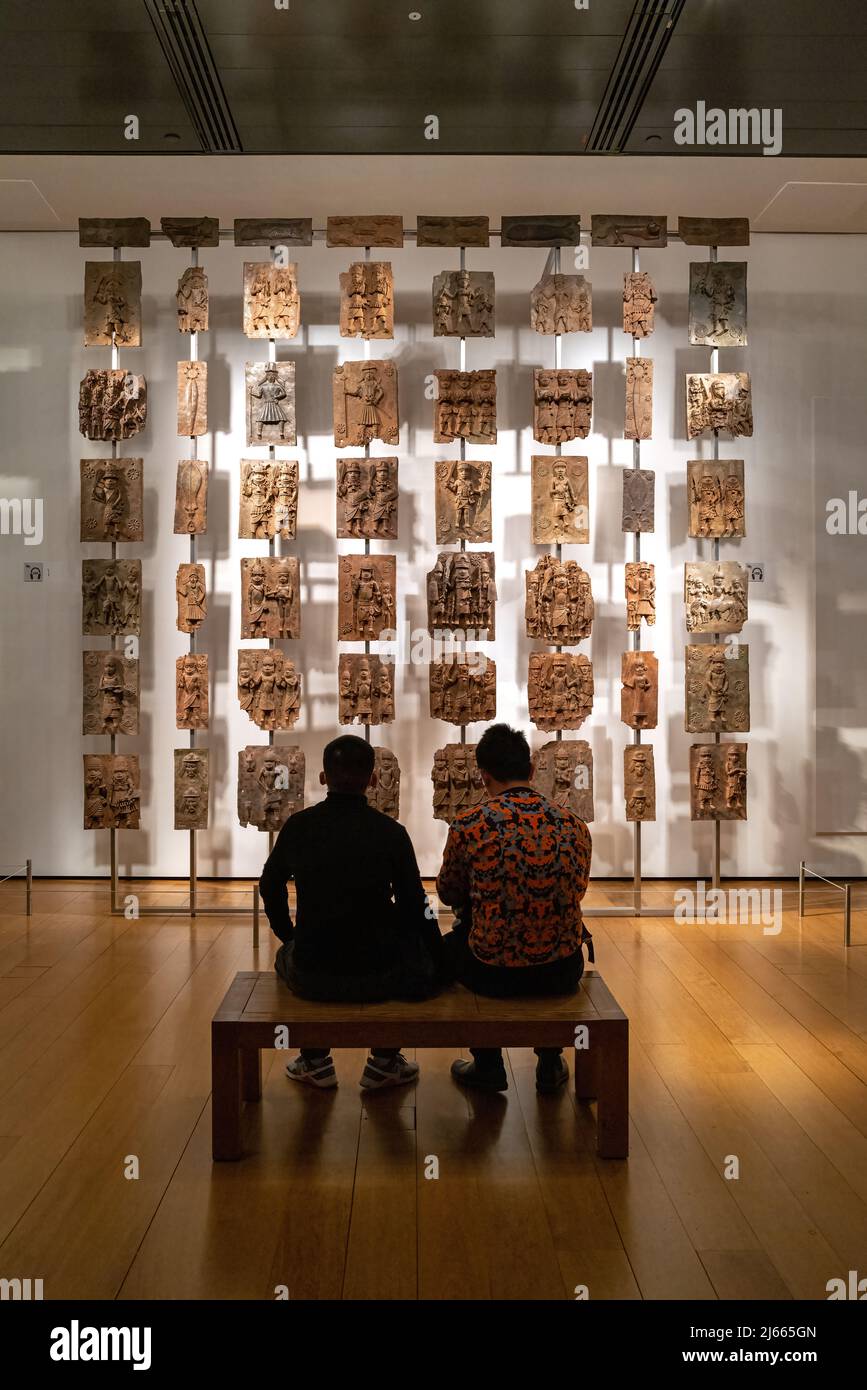 London, Großbritannien - 18.. April 2022: Die Bronzen aus Benin, Afrika-Galerie des British Museum, von Touristen bewundert. Aus dem Königspalast von Benin, jetzt Stockfoto