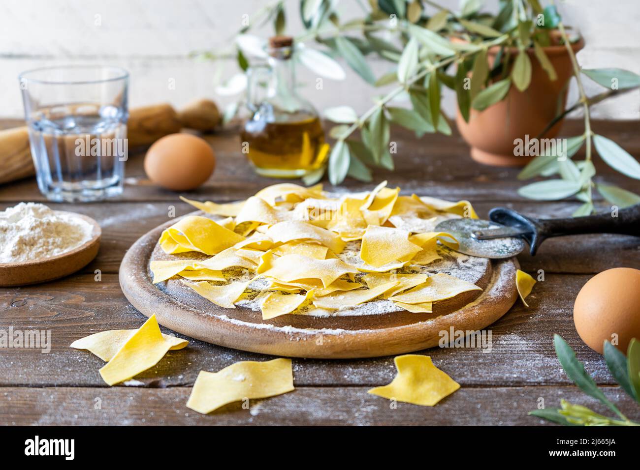 Hausgemachte Pasta Maltagliati auf Schneidebrett mit Zutaten auf Holz Hintergrund Stockfoto