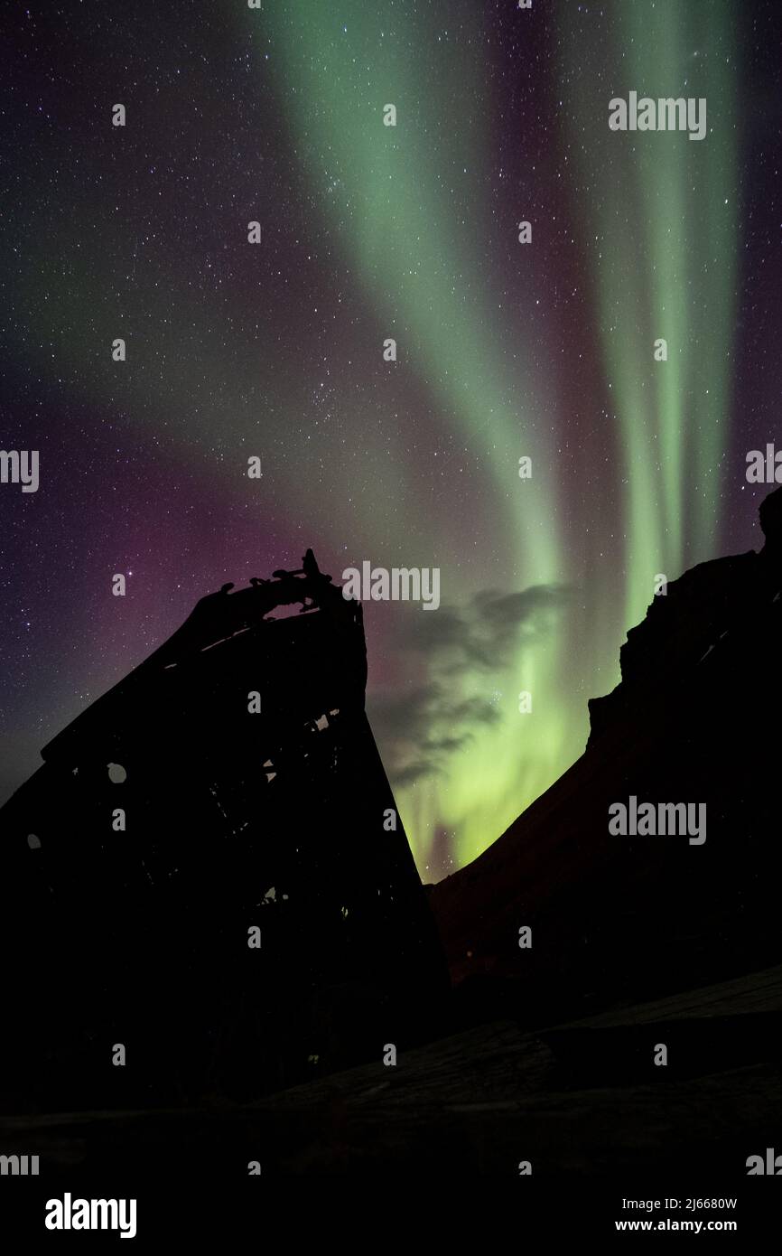 Aurora Borealis über dem alten Schiffsrack in Djúpavík, Westfjorde, Island - Nordlichter über einem alten Schiffswrack in den isländischen westfjorden Stockfoto