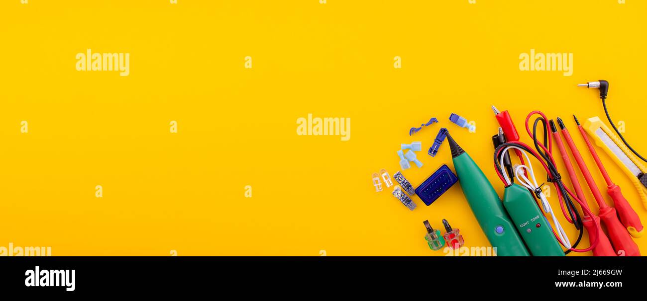 Anordnung von Werkzeugen für die Reparatur von Elektrokabeln auf gelbem Hintergrund. Selektiver Fokus Stockfoto
