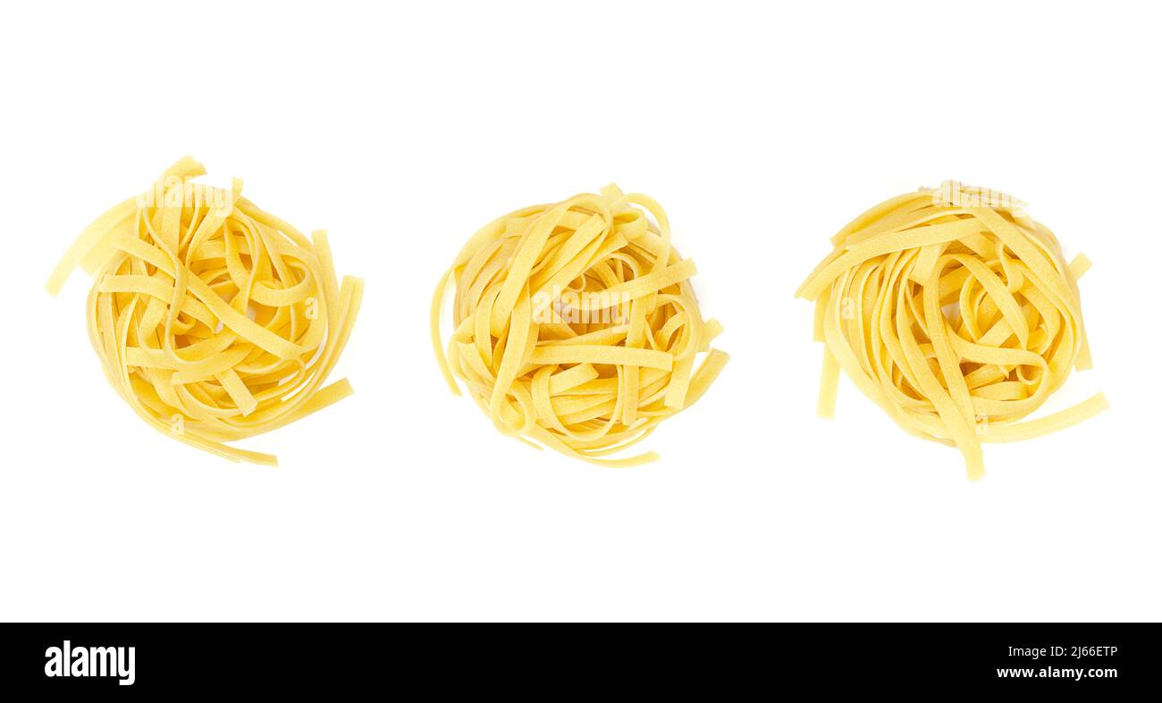 Drei ungekochte Tagliatelle-Nudelnester, in einer Reihe, von oben, auf weißem Hintergrund. Getrocknete, rohe traditionelle italienische Eiernudeln. Stockfoto