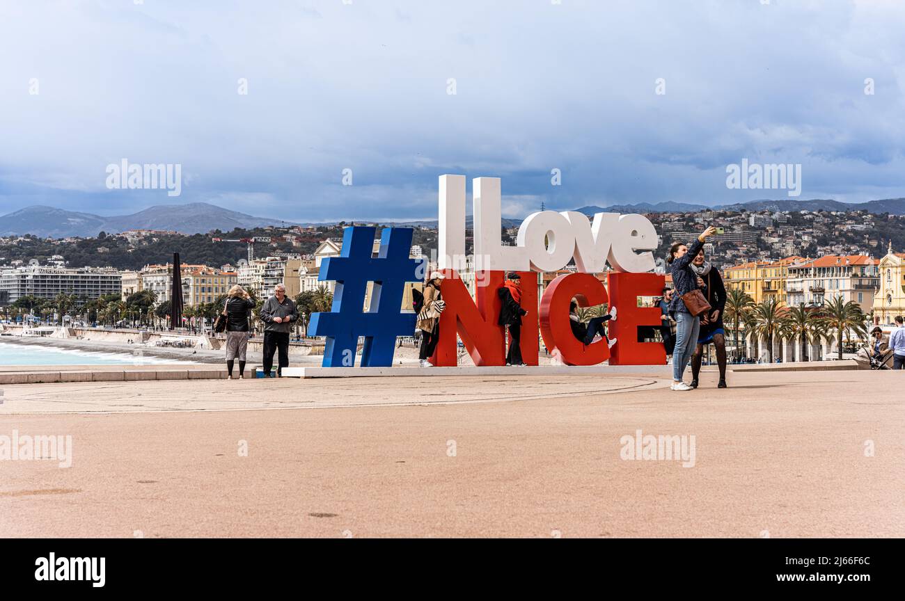 Nizza, Frankreich - April 2 2022 - Touristen posieren für ein Foto auf dem Schild „I Love Nice“ am Strand von Nizza Stockfoto