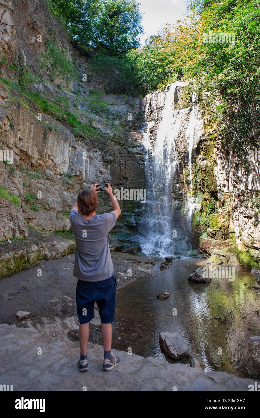 Junger Mann fotografiert die Schwefelwasserfall bei den Schwefelbaeder in Abanotubani, Schwefelthermalwasser, Bäderviertel Abanotubani, Tiflis Stockfoto