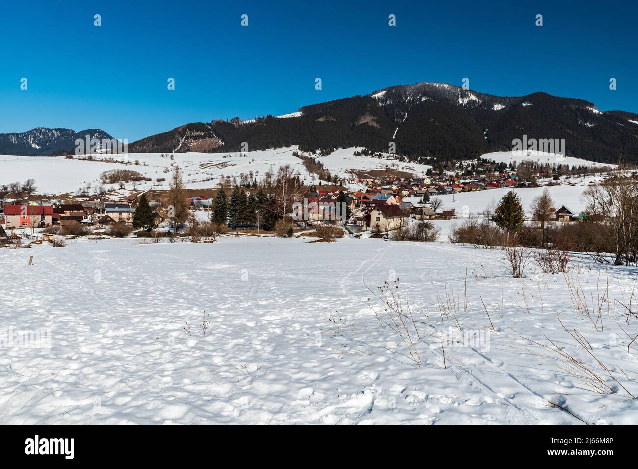 Liptovska Luzna Dorf mit Hügeln auf dem Hintergrund in der Slowakei während schönen Wintertag Stockfoto