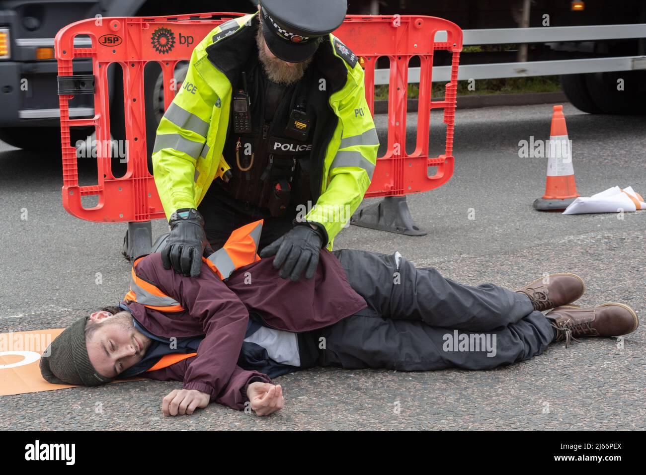 Kent, Großbritannien. 28. April 2022 Demonstranten von Just Stop Oil blockieren die BP-Garage bei Clacket Lane Services am M25. Die Polizei kommt, um alle Demonstranten zu entkleben und zu verhaften. Kredit: Denise Laura Baker/Alamy Live Nachrichten Stockfoto