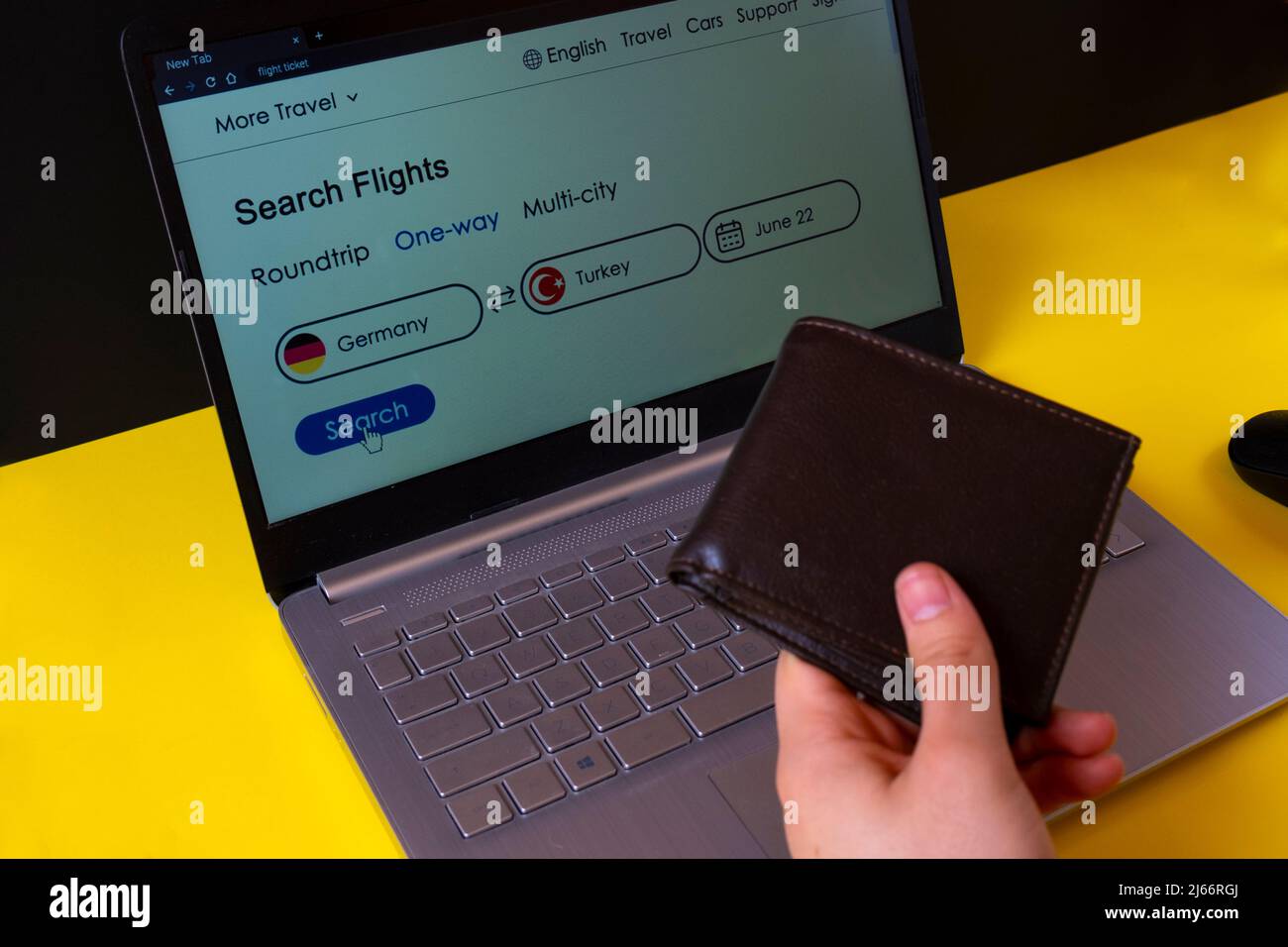 Man Hand hält Geldbörse mit Flugscheinbildschirm auf dem Hintergrund, Ziel zwischen Deutschland und der Türkei, Ticket für Sommerurlaub buchen Stockfoto