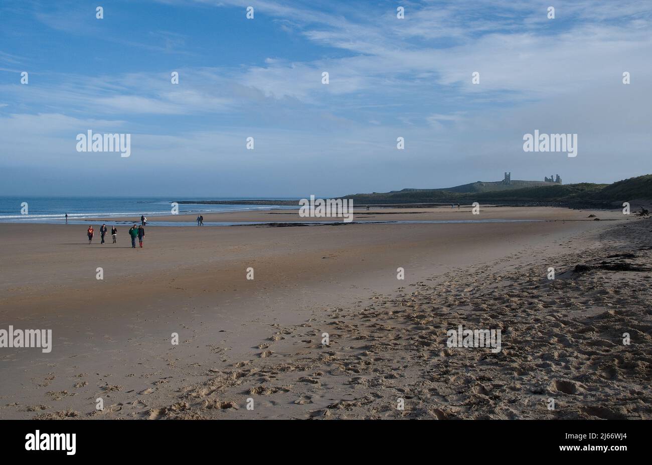 Breiter, weitläufige Strand der Embleton Bay mit Ebbe und einem fernen Dunstanburgh Castle am Horizont an einem Herbstnachmittag Stockfoto