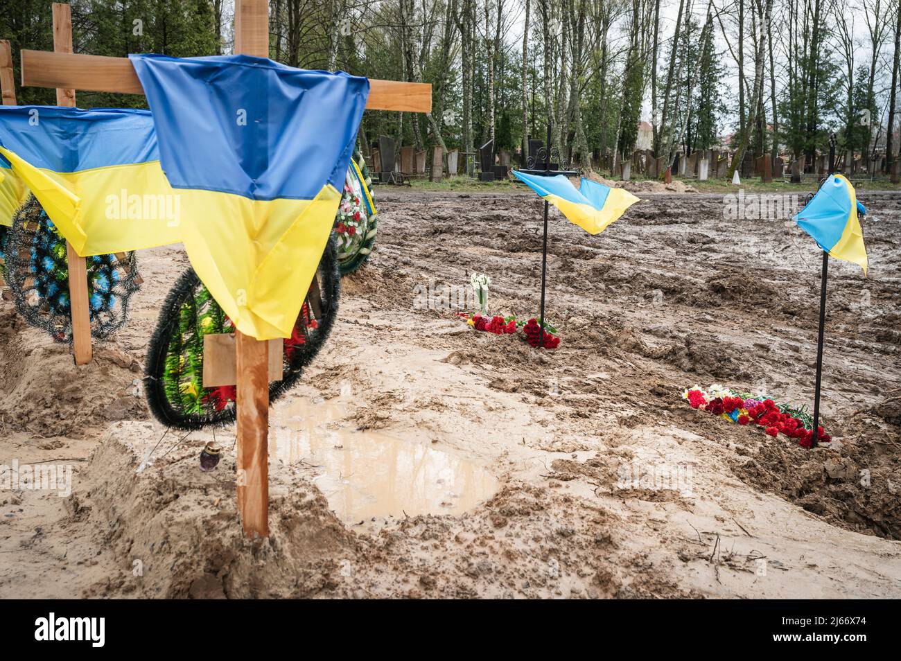 Gräber mit ukrainischen Flaggen auf dem Begräbnisgelände in Tschernihiv gesehen. In Tschernihiw, im Norden der Ukraine, wurde ein Massengrab für die Leichen von Menschen vorbereitet, die während der russischen Besatzung getötet wurden, da der örtliche Friedhof fast unzugänglich ist. Stockfoto