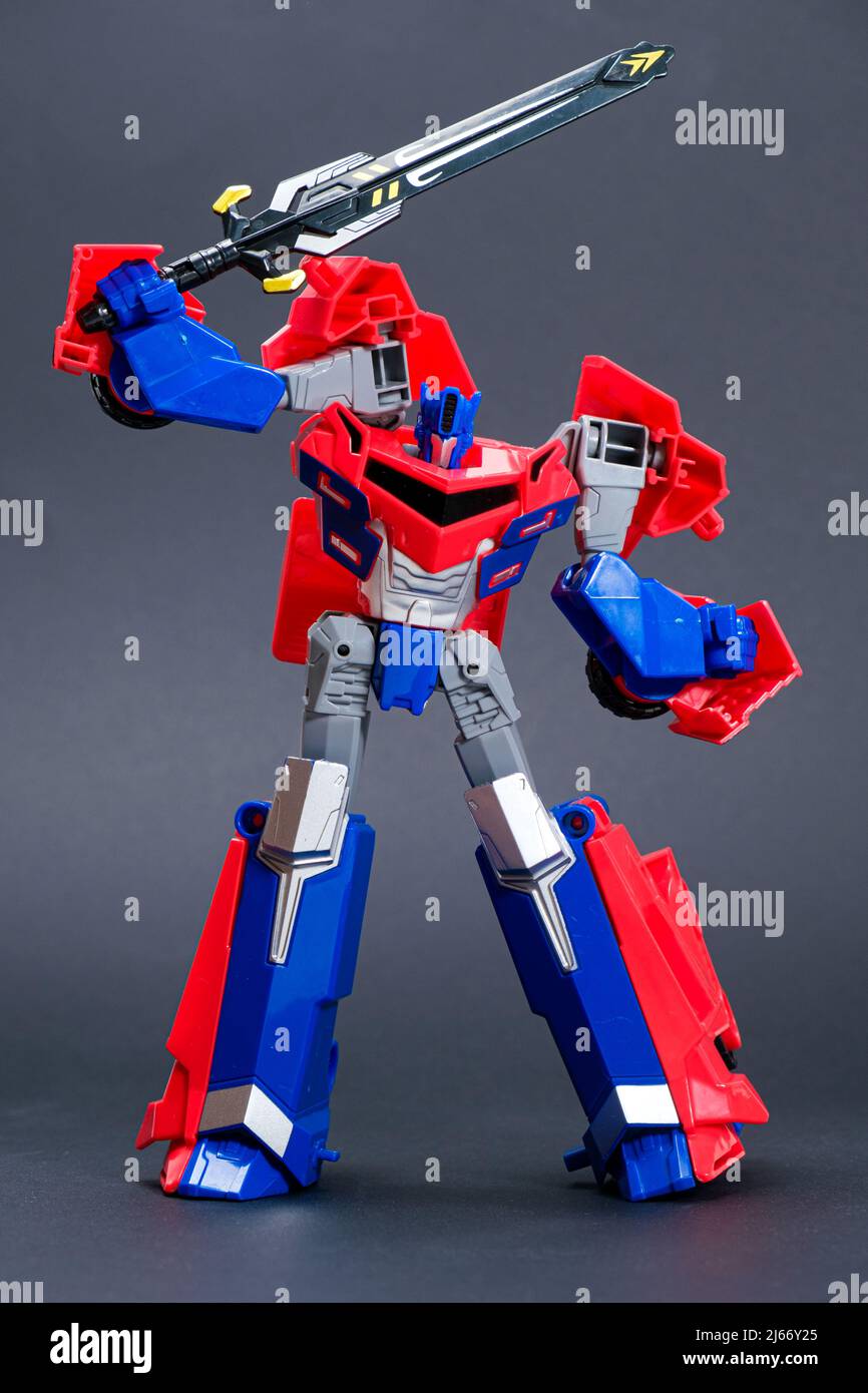 Roboter-Transformator rot und blau auf schwarzem Hintergrund. Spielzeug für Kinder, Spielwarenladen. Stockfoto