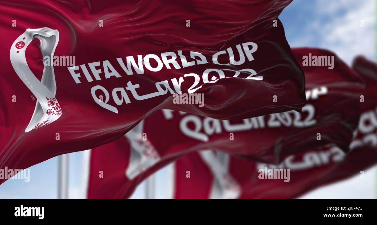 Doha, Katar, April 2022: Drei Flaggen mit dem Qatar 2022 FIFA World Cup-Logo winken im Wind. Die Veranstaltung ist vom 21. Bis 1. November in Katar geplant Stockfoto