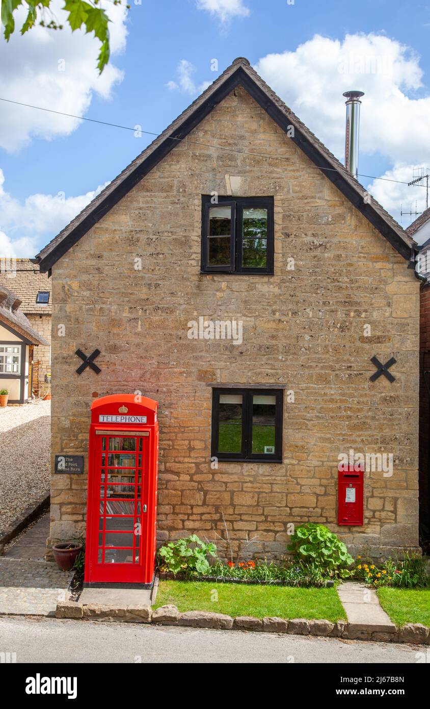 Rot-englischer Briefkasten und Telefonkiost werden jetzt als Buchaustausch im Dorf Ashton unter Hill Worcestershire genutzt Stockfoto