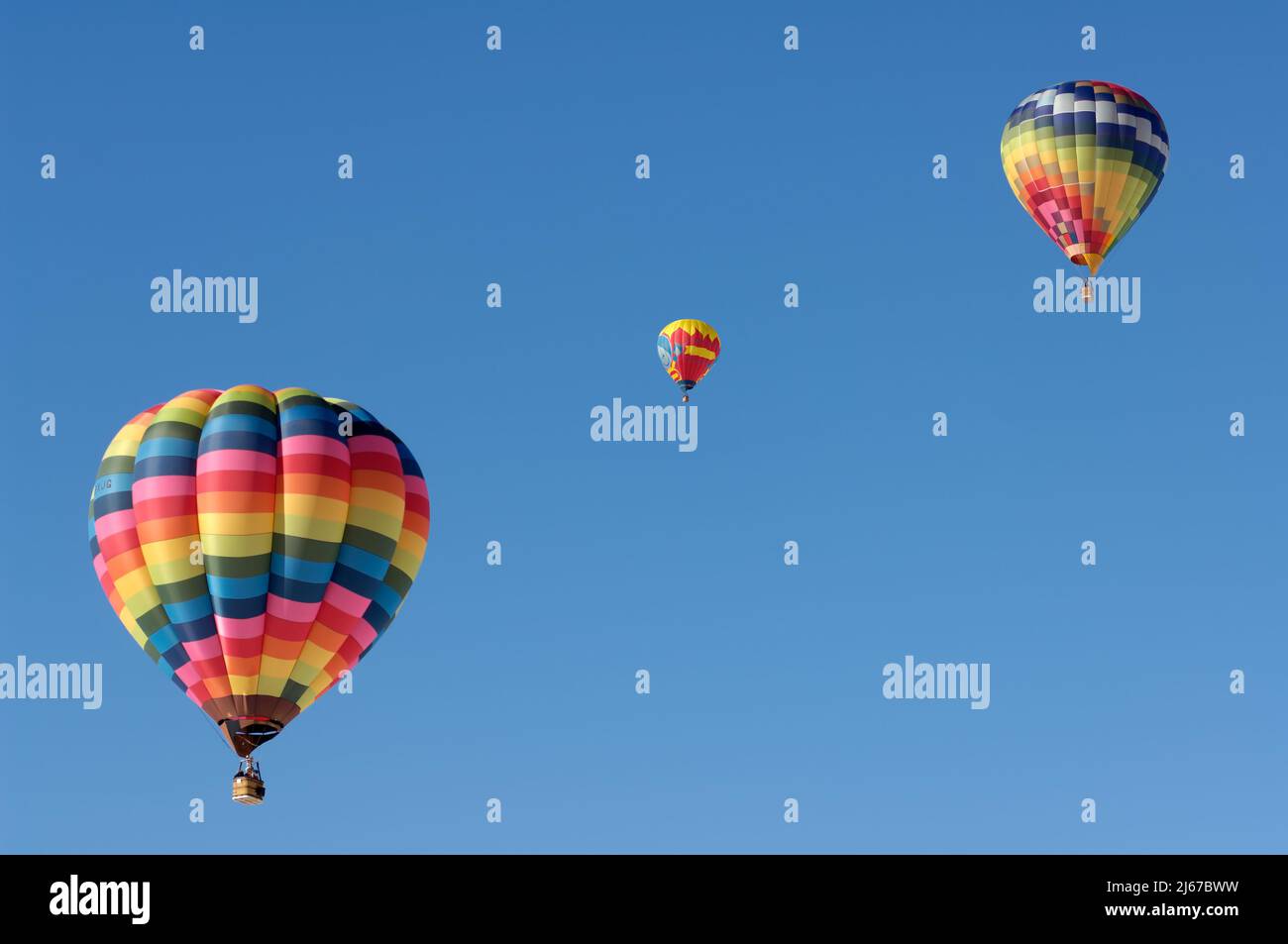 Drei bunte Heißluftballons schweben am blauen Himmel Stockfoto