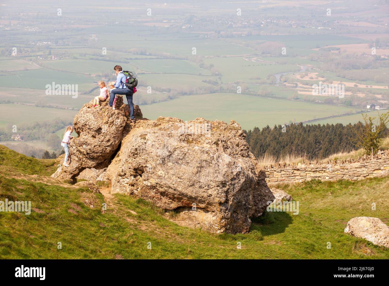 Familien und Kinder klettern auf dem Elefantenstein auf dem Gipfel des Bredon Hill im Vals of Evesham Worcestershire England Stockfoto