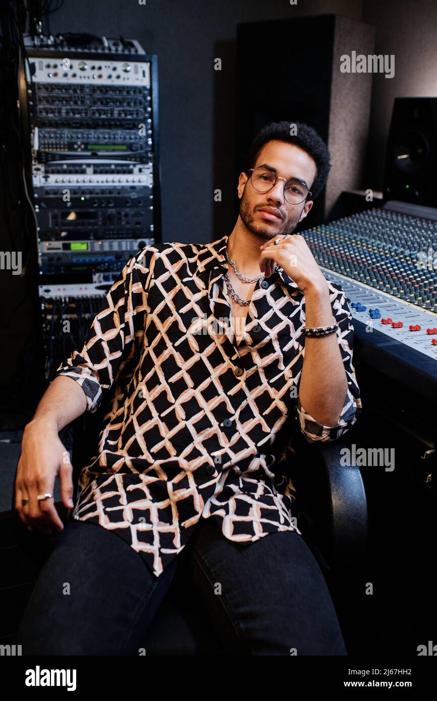 Porträt eines eleganten jungen schwarzen Mannes, der im Aufnahmestudio arbeitet und entspannt die Kamera anschaut Stockfoto