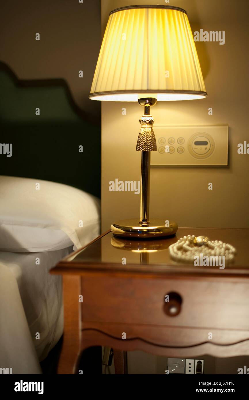 Nachttisch im Hotelzimmer mit Schmuck Stockfoto