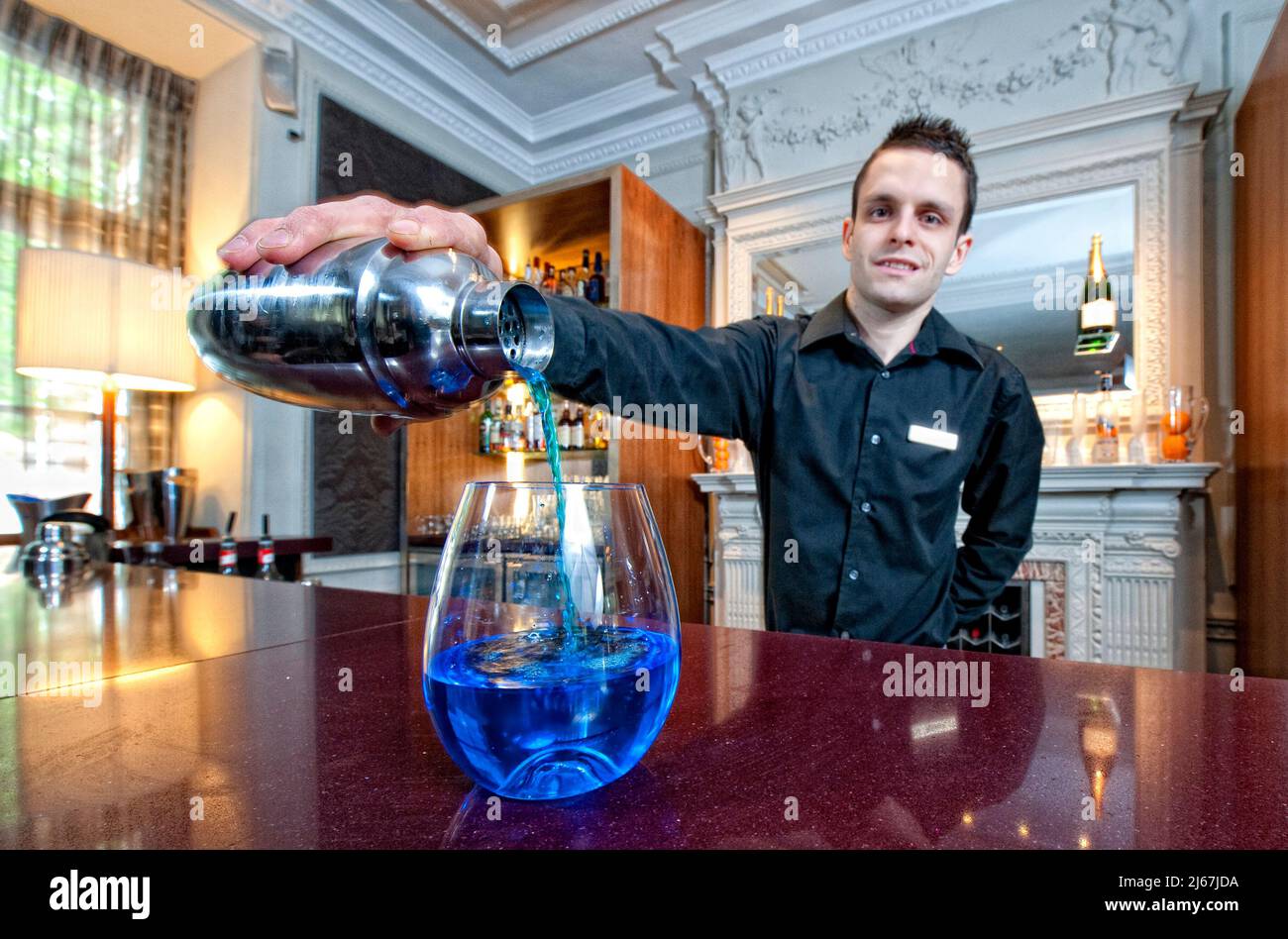 Der Barkeeper gießt einen blauen Cocktail an der Theke eines Luxushotels Stockfoto