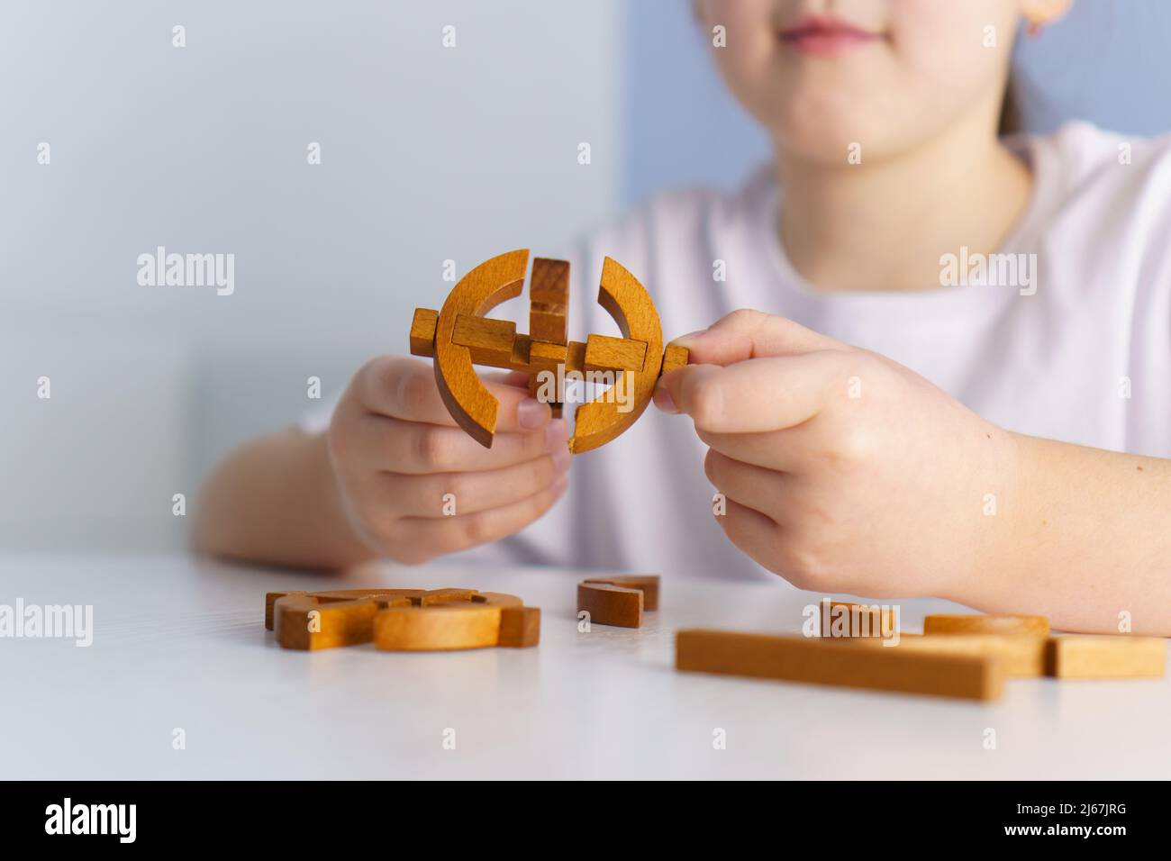 Nettes kleines Mädchen spielt mit hölzernen Puzzle-Blöcken zu Hause. Konzept für die Entwicklung und Bildung von Kindern Stockfoto