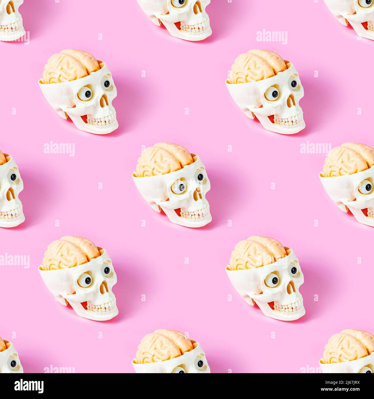 Weißer menschlicher Schädel mit Gehirn und Augen wiederholen nahtloses Muster auf hellrosa Hintergrund. Skelettkopf als Symbol des Todes und Halloween Verpackung pape Stockfoto