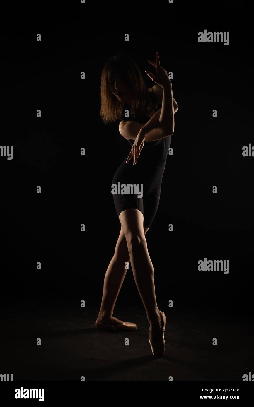 Silhouette der jungen Ballerina posiert und h olding ihre Haltung Stockfoto