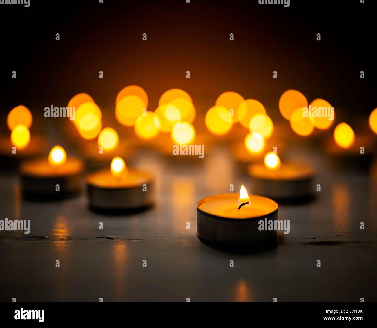 Brennende Teelichter, Kerzenlicht in der Nacht. Stockfoto