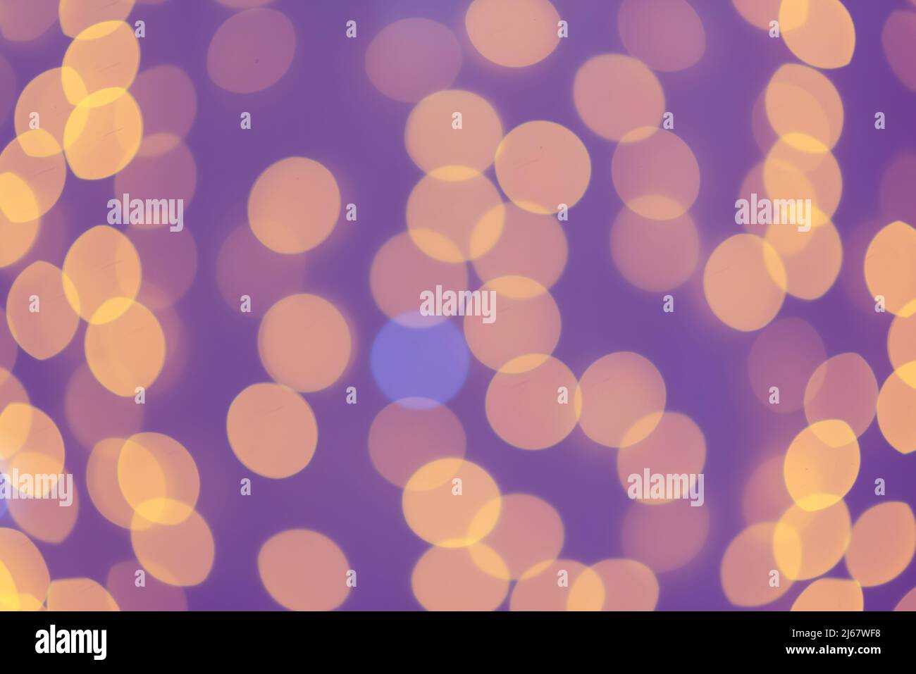 Verschwommenes abstraktes: Verschwommenes orangefarbenes Licht Kreise im violetten Hintergrund. Bokeh-Effekt Stockfoto