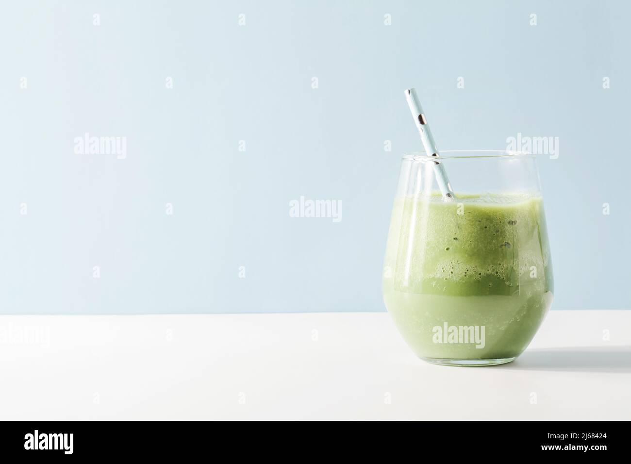 Gesunder grüner Smoothie im Glas mit Stroh auf blauem Hintergrund. Vegetarische gesunde Lebensweise Konzept.erfrischende Getränk kopieren Raum schnellen Snack Stockfoto