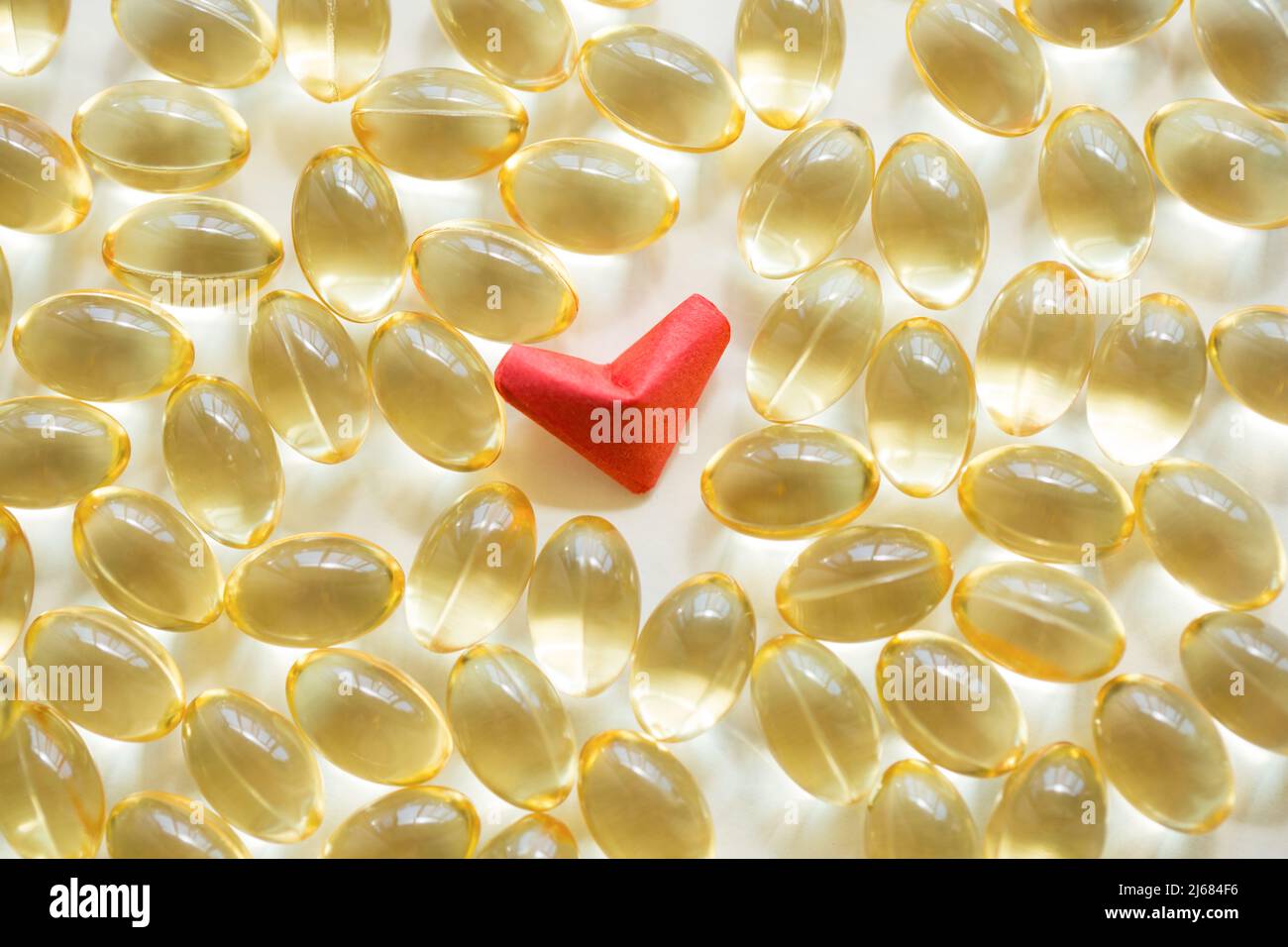 Rotes herzförmiges Origami und weiche Kapsel Softgel auf weißem Hintergrund - Stock Foto Stockfoto