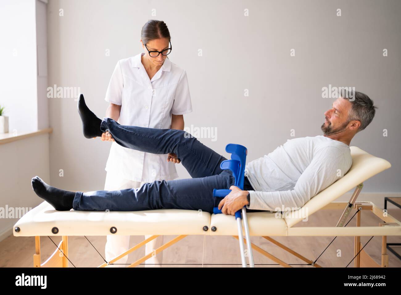 Physiotherapeut Überprüft Das Knie Des Patienten. Physiotherapie Und Schmerzen Stockfoto