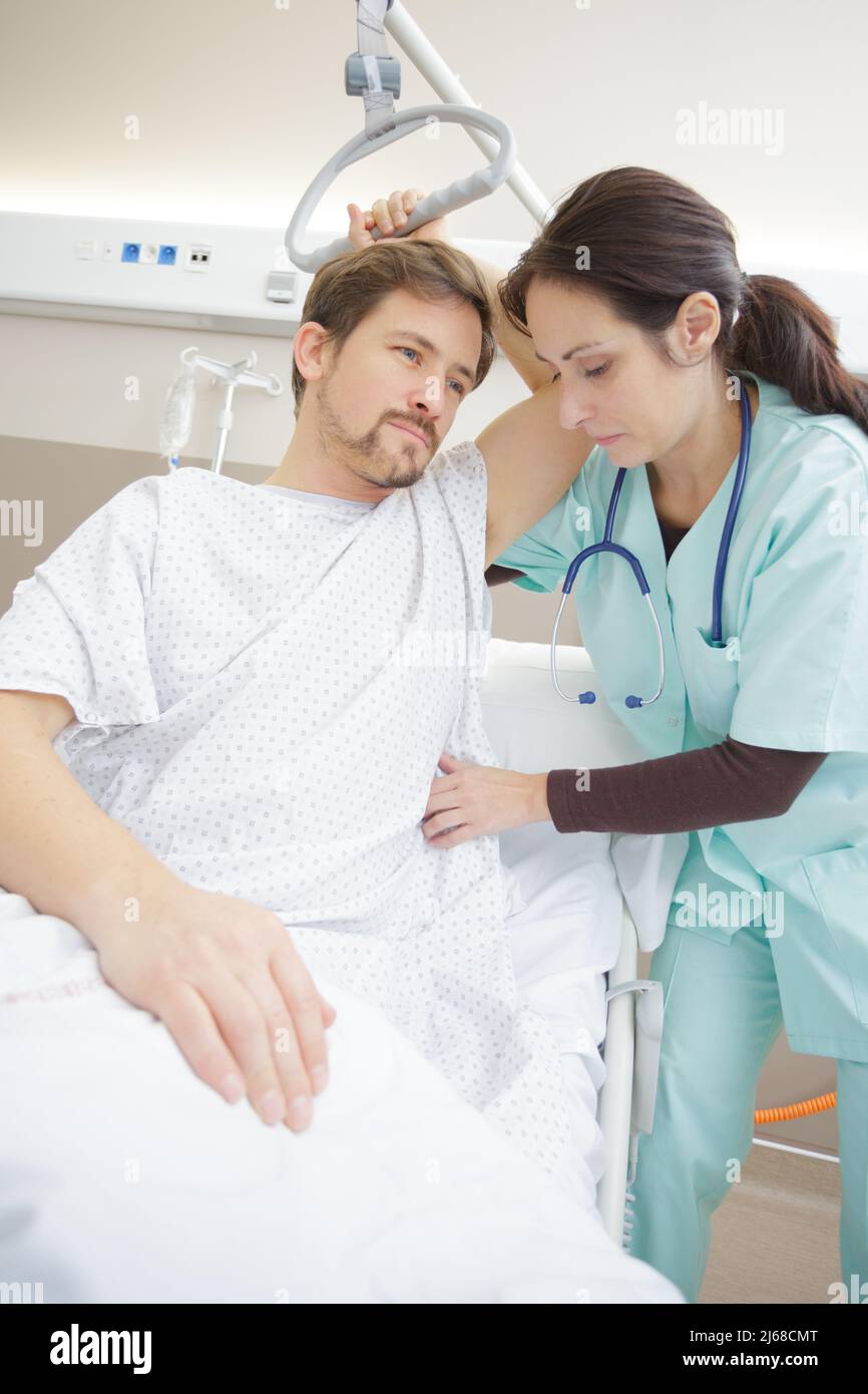 Pflegekraft, die den Hebezeug für den Patienten im Krankenhaus anpasst Stockfoto