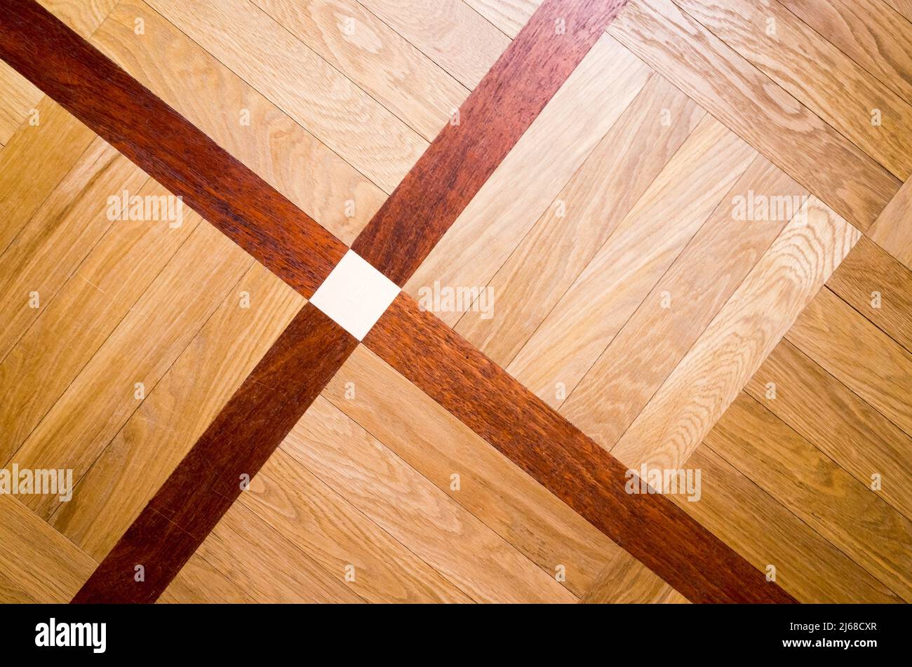 Vintage-Parkett mit geometrischem Ornament aus verschiedenen Hölzern. Hintergrund Foto Textur, Draufsicht Stockfoto
